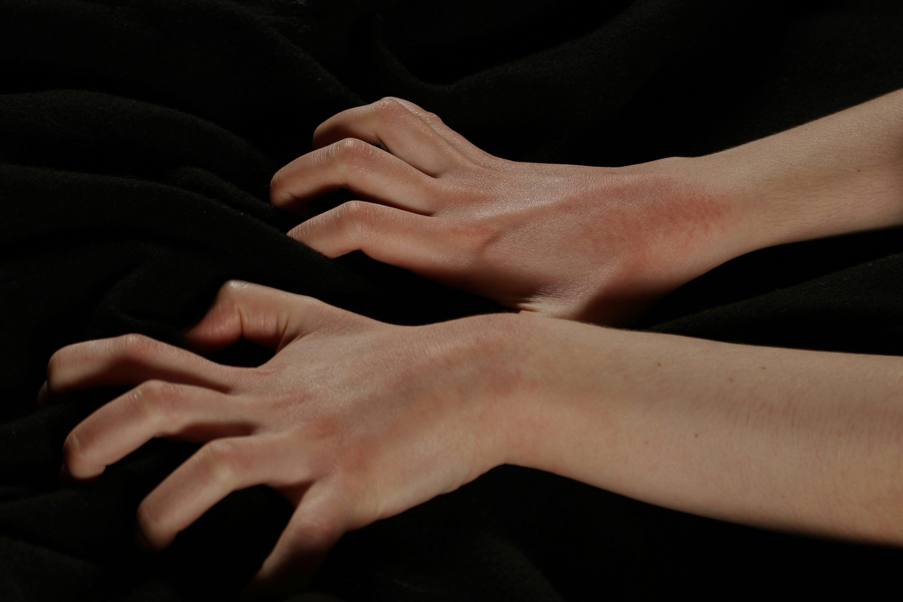 Close-up of two hands on a dark background