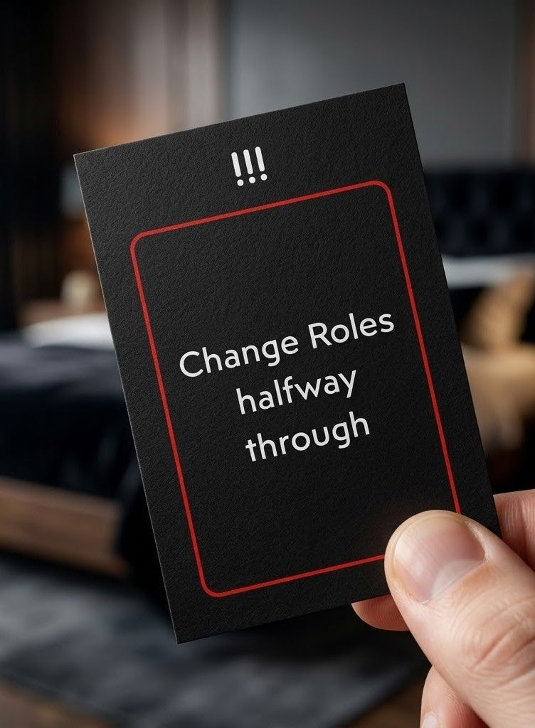 A hand holding a black card with a red border and white text that reads 'Change Roles halfway through' against a blurred indoor background.